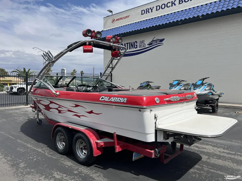 Slide: The Image of 2008 Calabria PRO V boat with red accents on a trailer at a marina. - 2