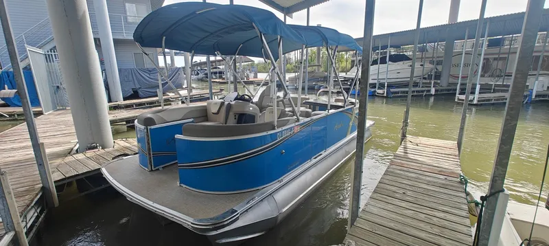 Slide: The Image of 2023 Avalon LSZ Entertainer pontoon boat docked under a canopy. - 0