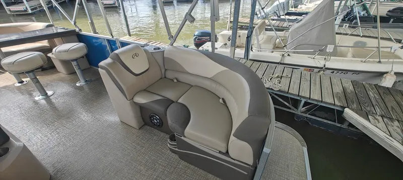 Slide: The Image of 2023 Avalon LSZ Entertainer boat with plush seating at a marina dock. - 10