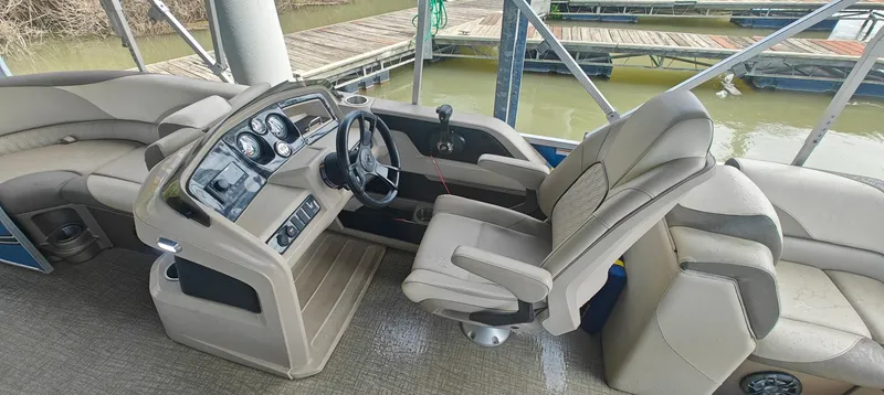 Slide: The Image of 2023 Avalon LSZ Entertainer boat interior with beige seating and modern dashboard. - 11