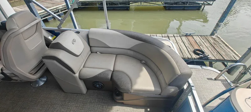Slide: The Image of 2023 Avalon LSZ Entertainer boat interior with plush seating by the dock. - 2