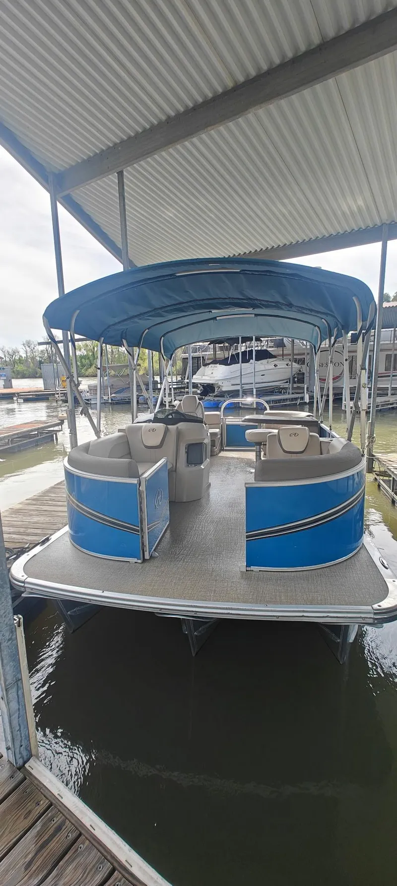 Slide: The Image of 2023 Avalon LSZ Entertainer pontoon boat docked under a canopy. - 3