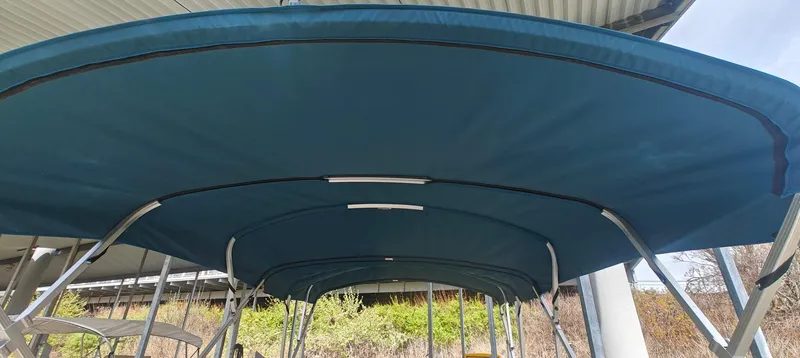 Slide: The Image of 2023 Avalon LSZ Entertainer boat canopy under a metal shelter. - 7