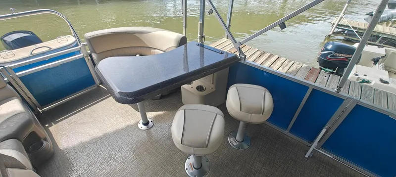 Slide: The Image of 2023 Avalon LSZ Entertainer boat interior with table and seating by the water. - 8