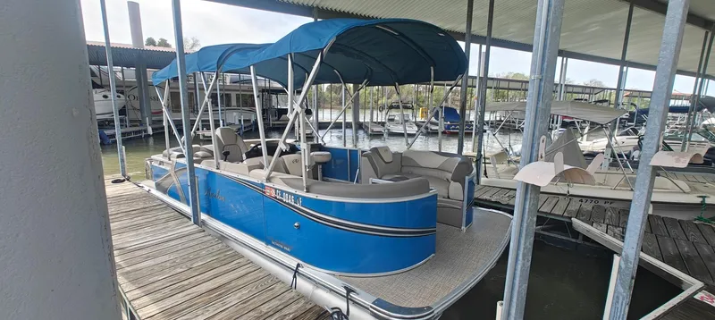 Slide: The Image of 2023 Avalon LSZ Entertainer pontoon boat docked under a covered marina. - 9