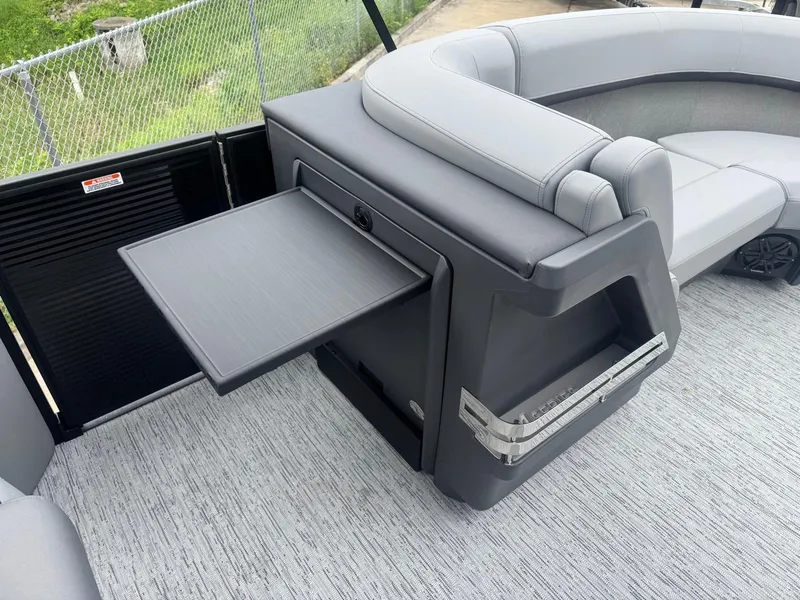 Slide: The Image of 2025 Bennington 22MFB boat interior with gray seating and a fold-out table. - 11