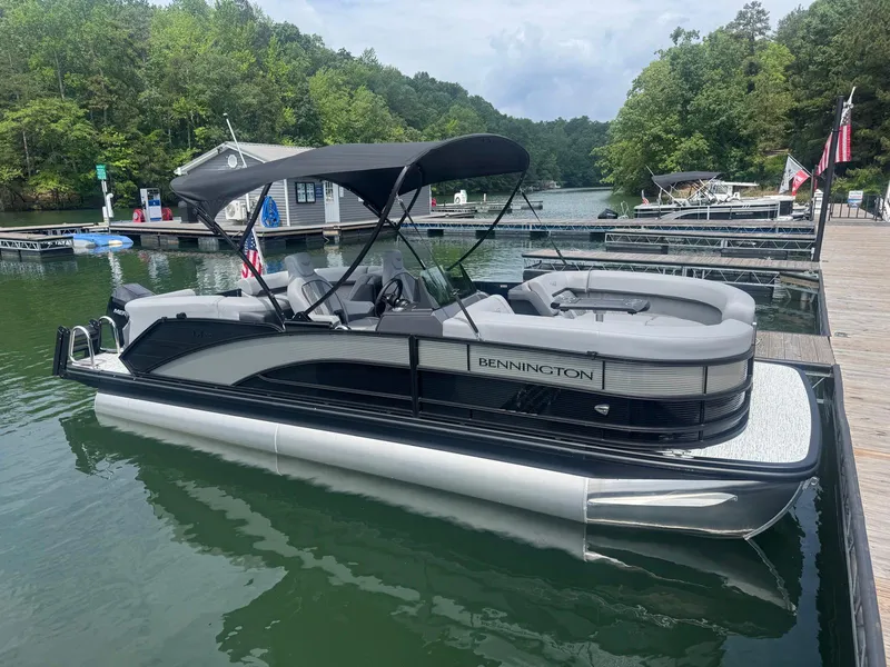 Slide: The Image of 2025 Bennington 22MFB pontoon boat docked on a serene lake with lush greenery. - 13