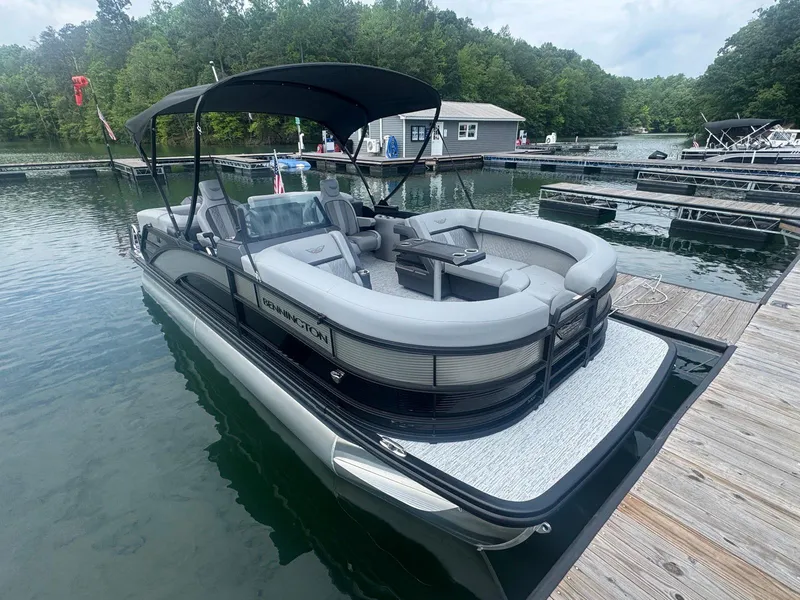 Slide: The Image of 2025 Bennington 22MFB pontoon boat docked on a serene lake. - 15