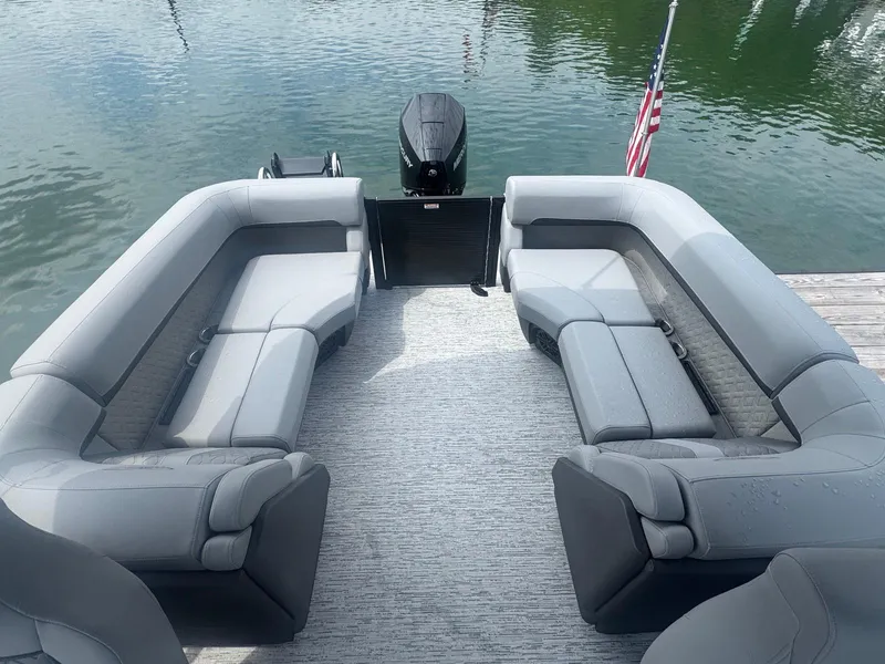 Slide: The Image of 2025 Bennington 22MFB pontoon boat with spacious seating and American flag on calm water. - 19