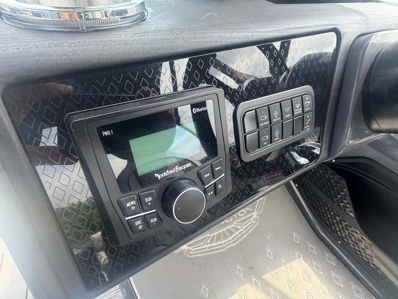Slide: The Image of Dashboard of 2025 Bennington 22MFB with Rockford Fosgate audio system and control panel. - 21