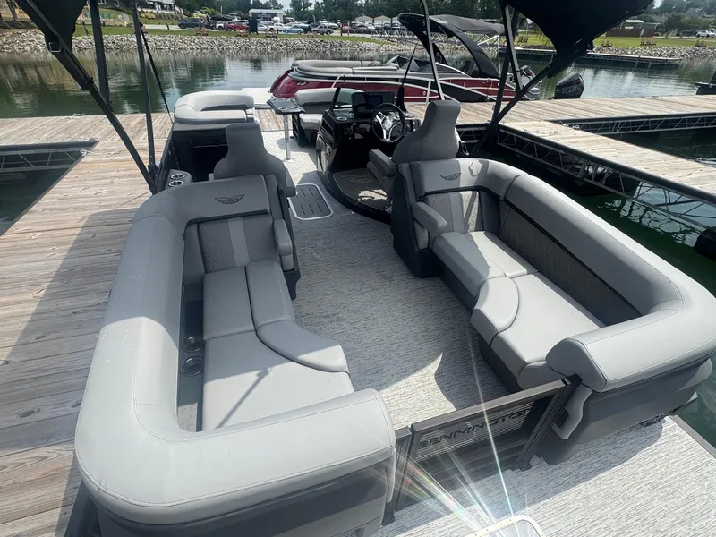 Slide: The Image of 2025 Bennington 22MFB pontoon boat with spacious seating, docked by a serene lake. - 24