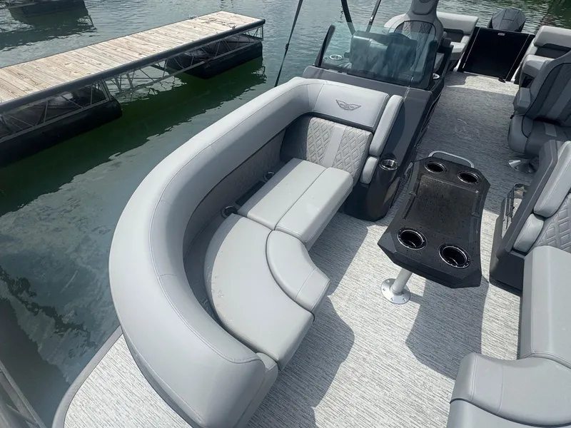 Slide: The Image of 2025 Bennington 22MFB pontoon boat with luxurious seating and cup holders, docked by the water. - 28