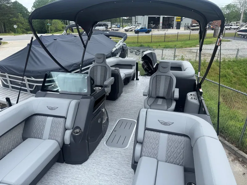 Slide: The Image of 2025 Bennington 22MFB pontoon boat with luxurious seating and canopy in a marina setting. - 5