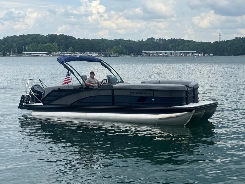 Slide: The Image of 2025 Bennington 24MFB pontoon boat on a lake with a person onboard. - 15