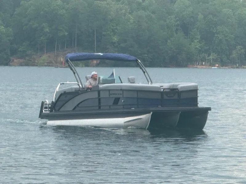 Slide: The Image of 2025 Bennington 24MFB pontoon boat cruising on a serene lake. - 18