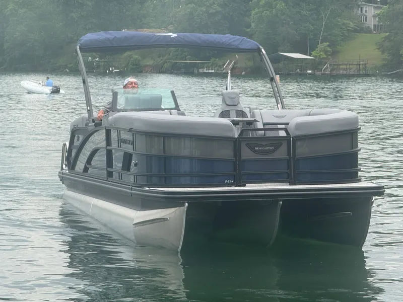 Slide: The Image of 2025 Bennington 24MFB pontoon boat cruising on a serene lake. - 21