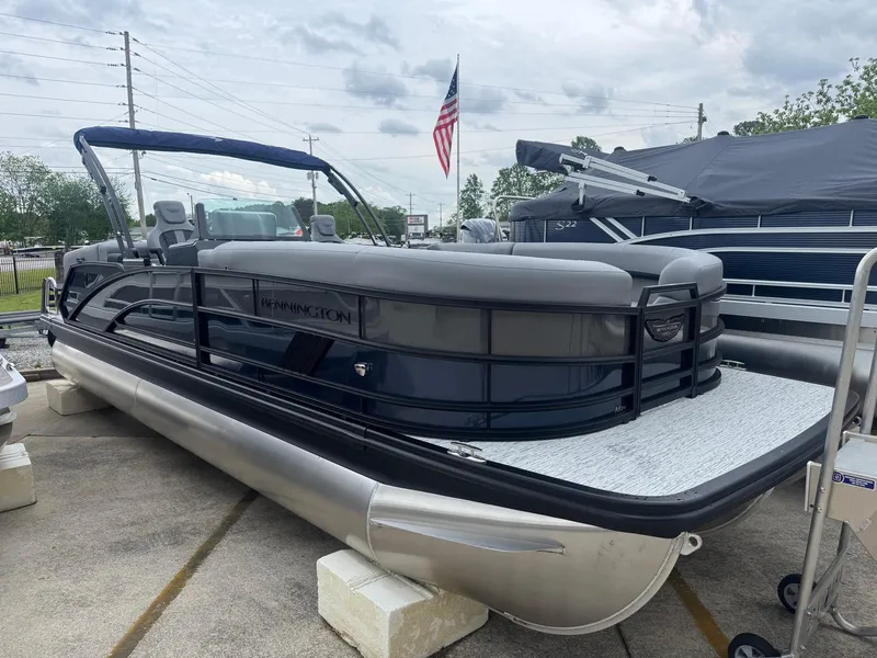 Slide: The Image of 2025 Bennington 24MFB pontoon boat displayed outdoors with American flag in background. - 3