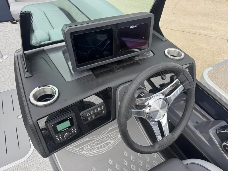 Slide: The Image of 2025 Bennington 24MFB boat dashboard with steering wheel and digital display. - 6