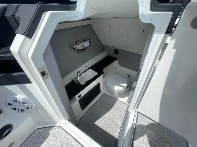 Slide: The Image of 2022 Cobalt R8 boat interior with compact bathroom, featuring a sink and toilet. - 8