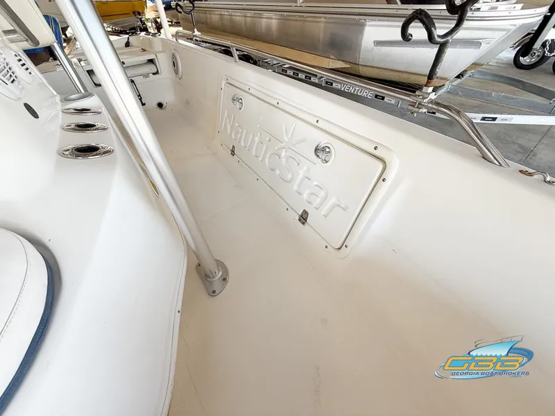 Slide: The Image of 2004 NauticStar 1900 Nautic Bay boat interior with storage compartment and rod holders. - 23