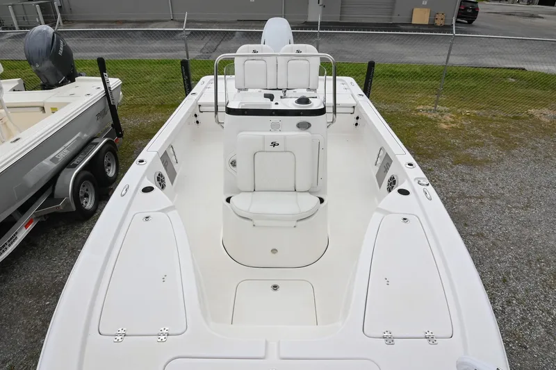 Slide: The Image of 2021 Sea Pro 208 Bay boat, white interior, spacious deck, parked on gravel near trailer. - 9