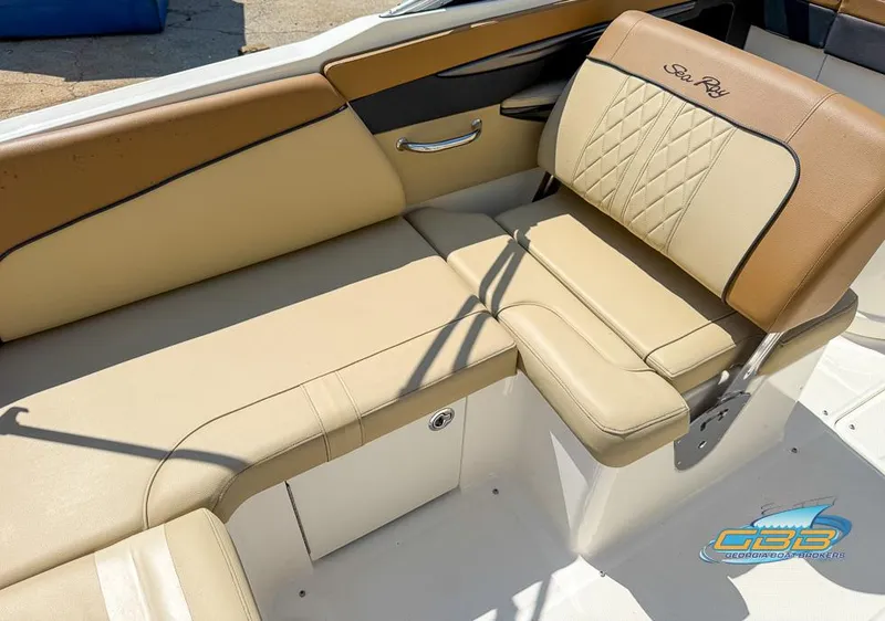 Slide: The Image of 2015 Sea Ray 240 Sundeck interior with beige seating and storage compartment. - 10