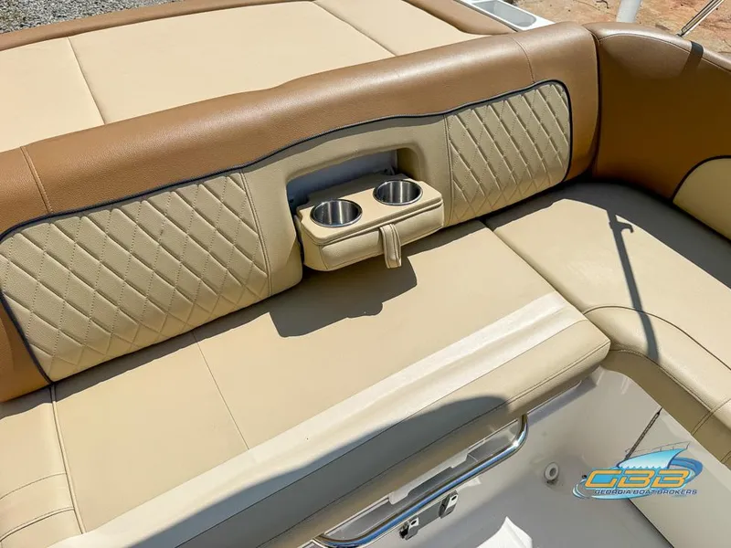 Slide: The Image of 2015 Sea Ray 240 Sundeck boat interior with tan leather seating and built-in cup holders. - 12