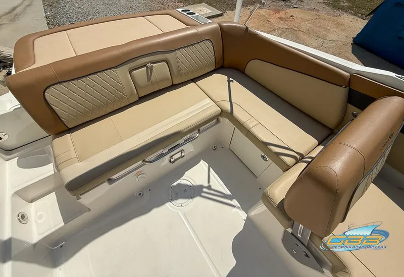 Slide: The Image of 2015 Sea Ray 240 Sundeck interior with tan leather seating and storage compartments. - 13