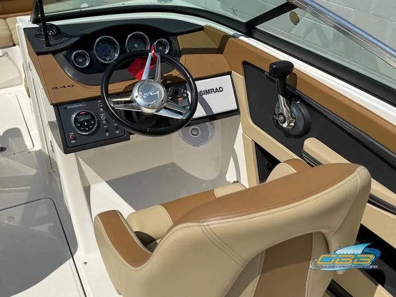 Slide: The Image of 2015 Sea Ray 240 Sundeck boat cockpit with steering wheel and control panel. - 16