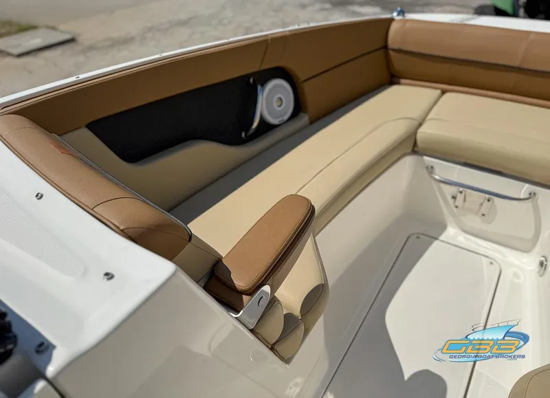 Slide: The Image of 2015 Sea Ray 240 Sundeck interior with tan seating and speaker detail. - 20