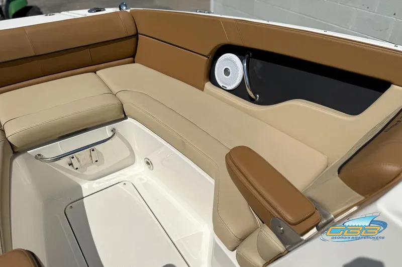 Slide: The Image of 2015 Sea Ray 240 Sundeck interior with tan seating and speaker detail. - 21