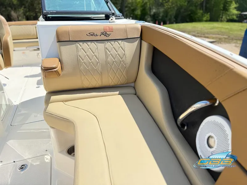 Slide: The Image of 2015 Sea Ray 240 Sundeck interior with tan seating and speaker detail. - 22