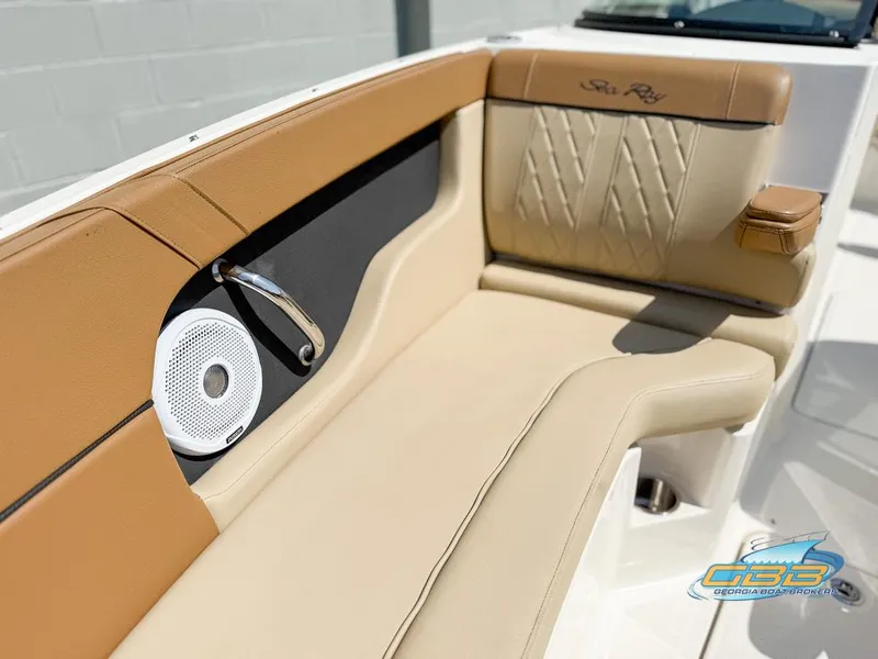 Slide: The Image of 2015 Sea Ray 240 Sundeck interior with tan seating and speaker detail. - 23