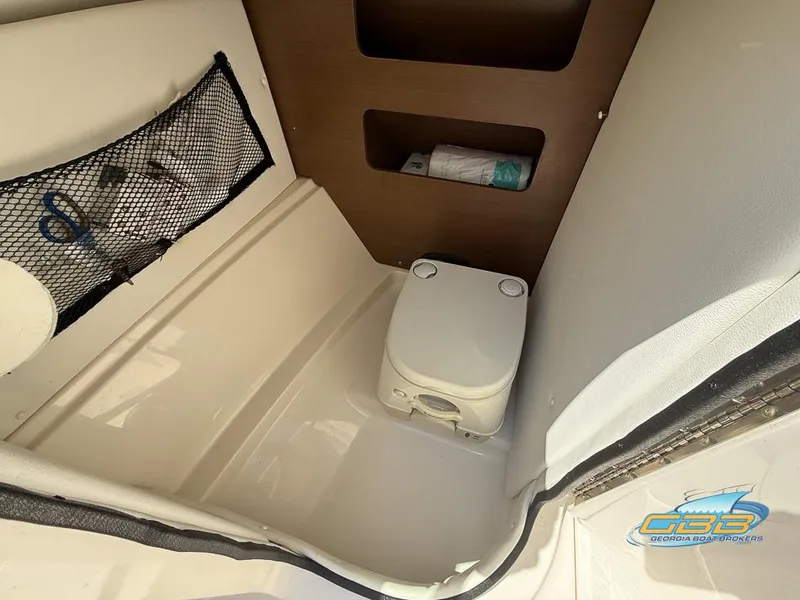 Slide: The Image of Interior of 2015 Sea Ray 240 Sundeck with portable toilet and storage compartments. - 26