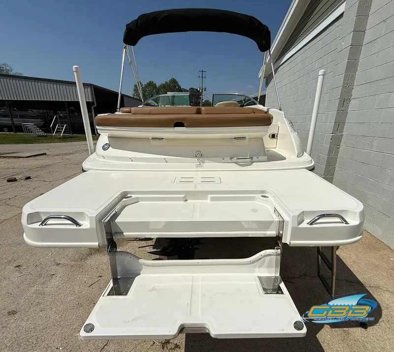 Slide: The Image of 2015 Sea Ray 240 Sundeck boat with swim platform and seating, docked outdoors. - 28