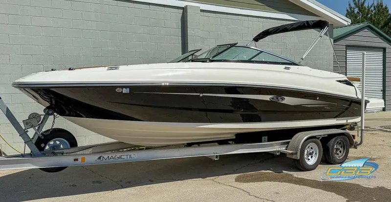 Slide: The Image of 2015 Sea Ray 240 Sundeck boat on trailer, black and white exterior, parked outdoors. - 3