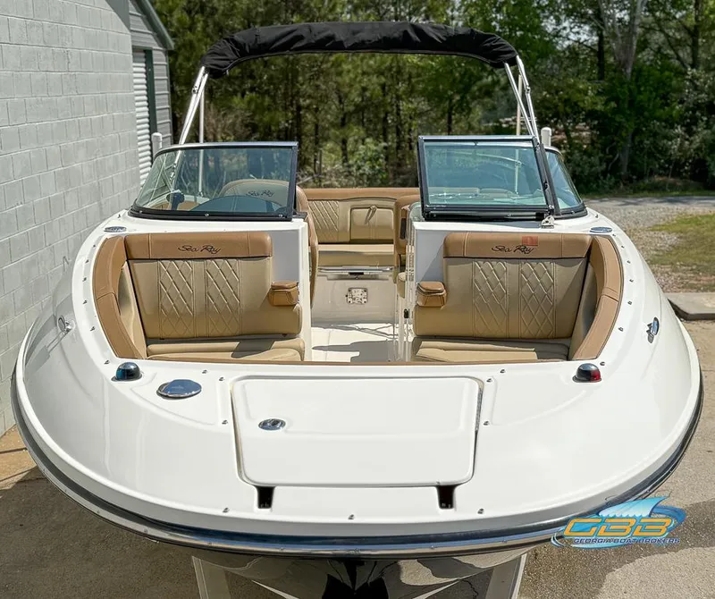 Slide: The Image of 2015 Sea Ray 240 Sundeck boat with tan seating and black canopy, docked outdoors. - 8