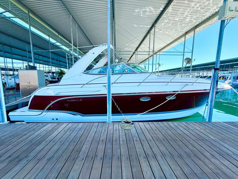 Slide: The Image of 2007 Formula 34 Cruiser docked under a covered marina, showcasing sleek design and red accents. - 8