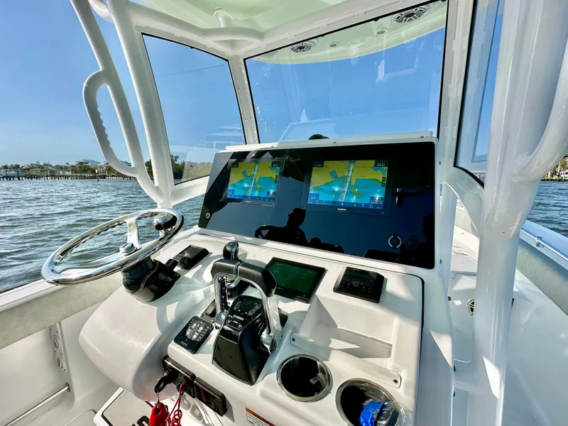 Slide: The Image of 2020 Sportsman Open 282 Center Console boat dashboard with dual screens on a sunny day. - 11