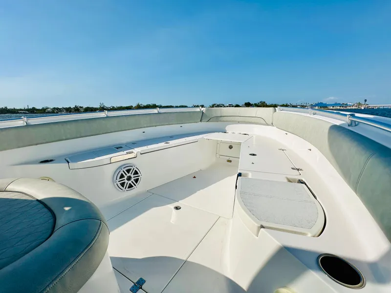 Slide: The Image of 2020 Sportsman Open 282 Center Console boat interior with seating and speaker, under clear blue sky. - 15
