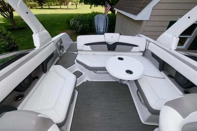 Slide: The Image of 2022 Four Winns HD5 OB boat interior with spacious seating and round table. - 7