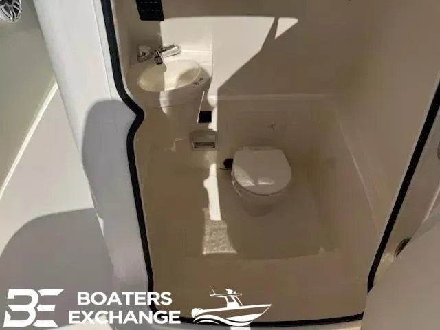 Slide: The Image of 2020 Cobia 262 boat interior bathroom with toilet and sink, Boaters Exchange logo. - 8