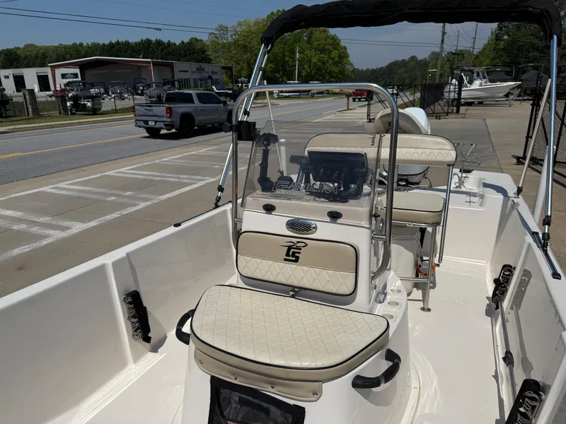 Slide: The Image of 2021 Carolina Skiff 192 JLS boat with beige seating, parked near a road. - 15