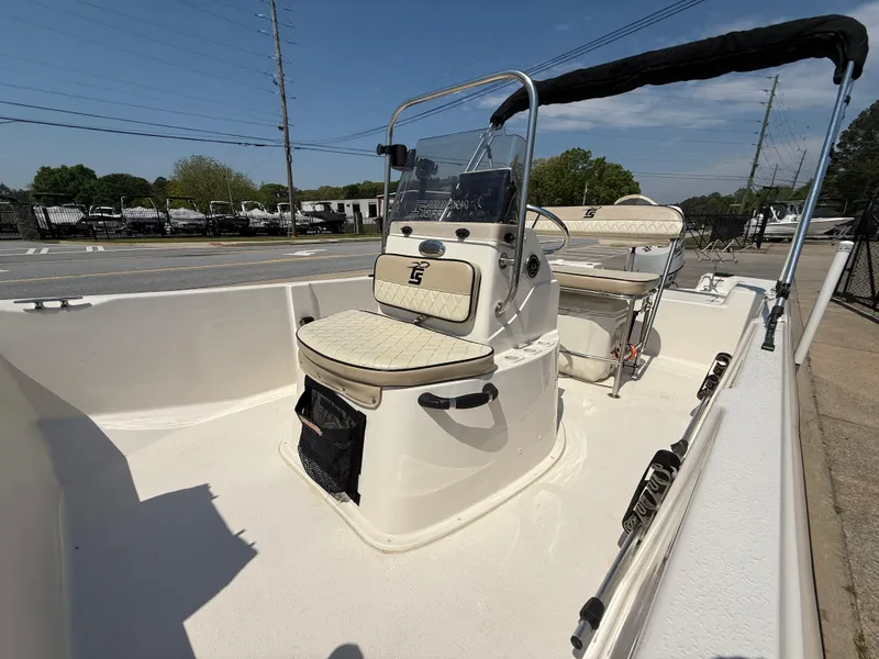 Slide: The Image of 2021 Carolina Skiff 192 JLS boat with center console and seating, parked outdoors. - 16