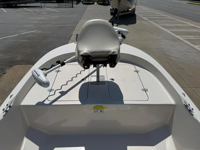 Slide: The Image of 2021 Carolina Skiff 192 JLS boat with seating and trolling motor, parked on pavement. - 19