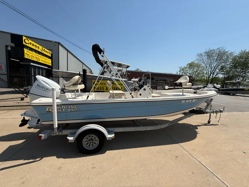 Slide: The Image of 2021 Carolina Skiff 192 JLS boat on trailer, parked outdoors under clear sky. - 9