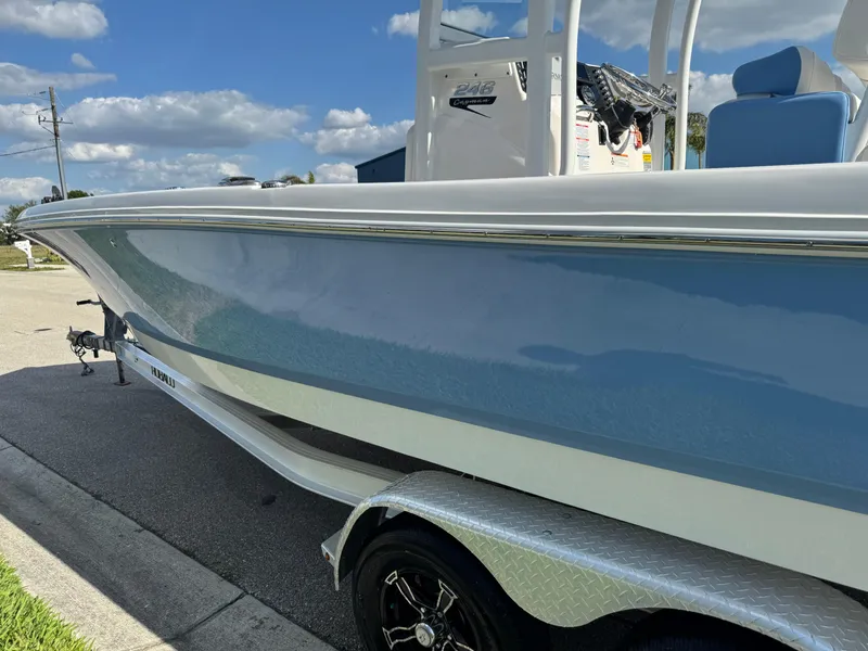 Slide: The Image of 2023 Robalo 246 Cayman boat on trailer, blue hull, sunny day. - 16