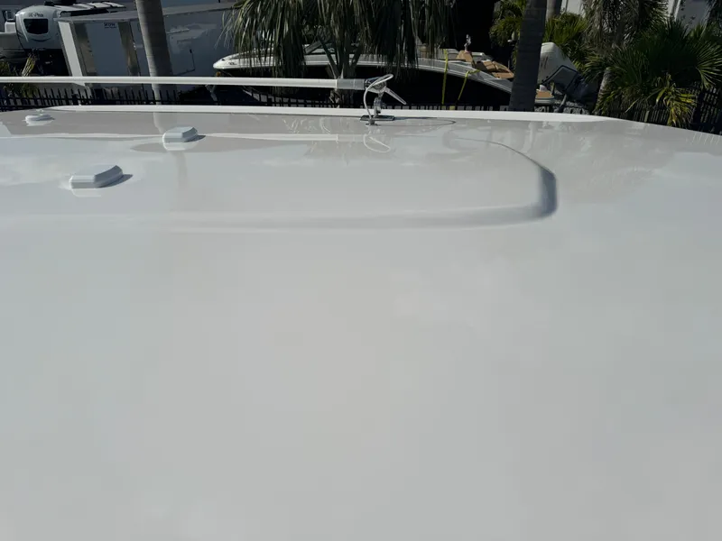 Slide: The Image of 2023 Robalo 246 Cayman boat deck, sleek and glossy finish, surrounded by palm trees. - 31