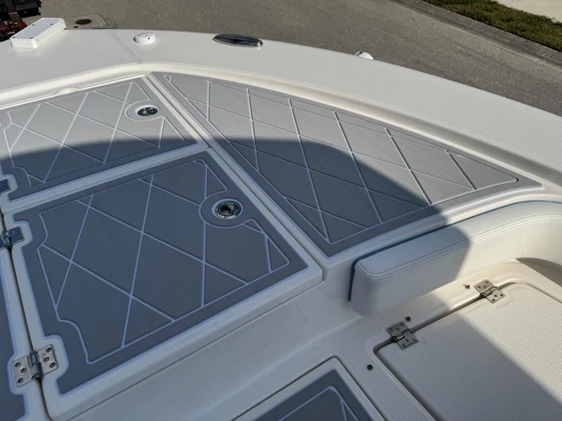 Slide: The Image of 2023 Robalo 246 Cayman boat deck with gray non-slip surface and storage compartments. - 35