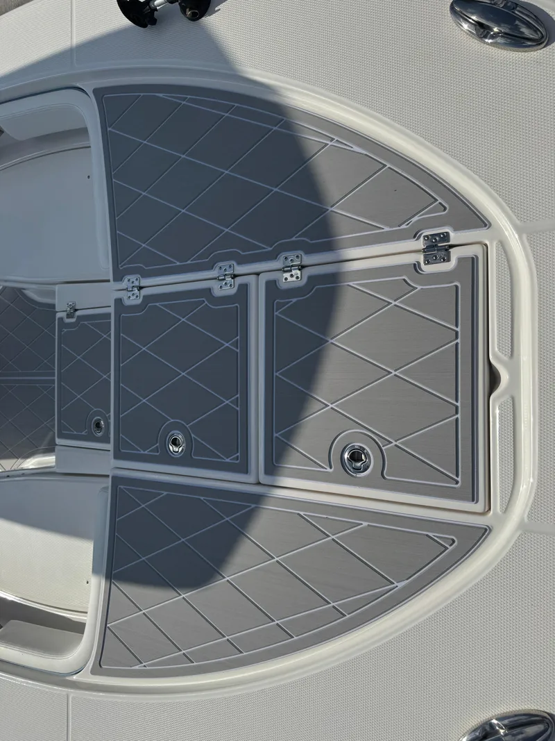 Slide: The Image of 2023 Robalo 246 Cayman boat deck with gray non-slip surface and storage compartments. - 37